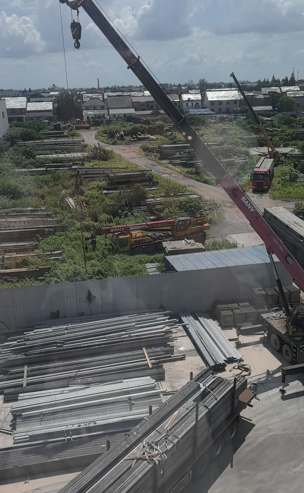 瀚泽货场俯拍全景:吊车与成排码放的型钢料垛